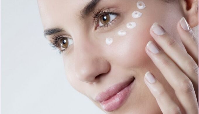 Rejuvenecer la piel del contorno de ojos con crema.