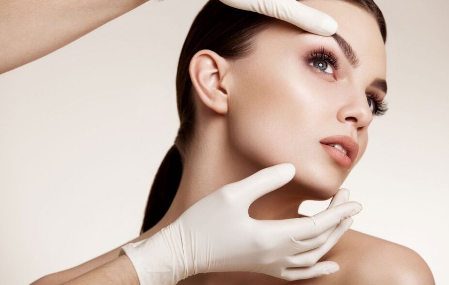 cosmetóloga examina la piel de la cara antes del rejuvenecimiento